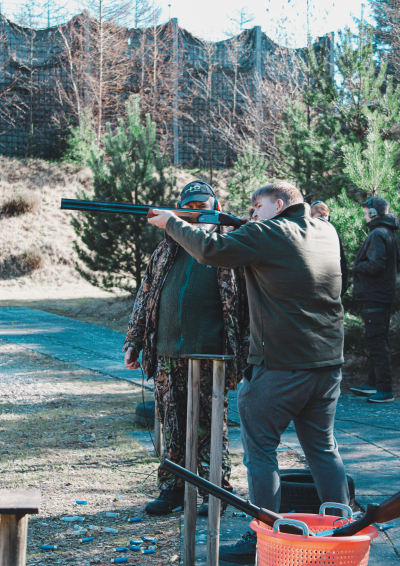 Mand skyder med haglgevær på skydebane