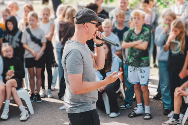 Pædagog står i midten af cirkel, med unge rundt om.